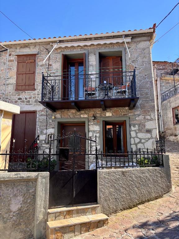an old stone house with a balcony and stairs at Diamanti Stone House in Lafiónas