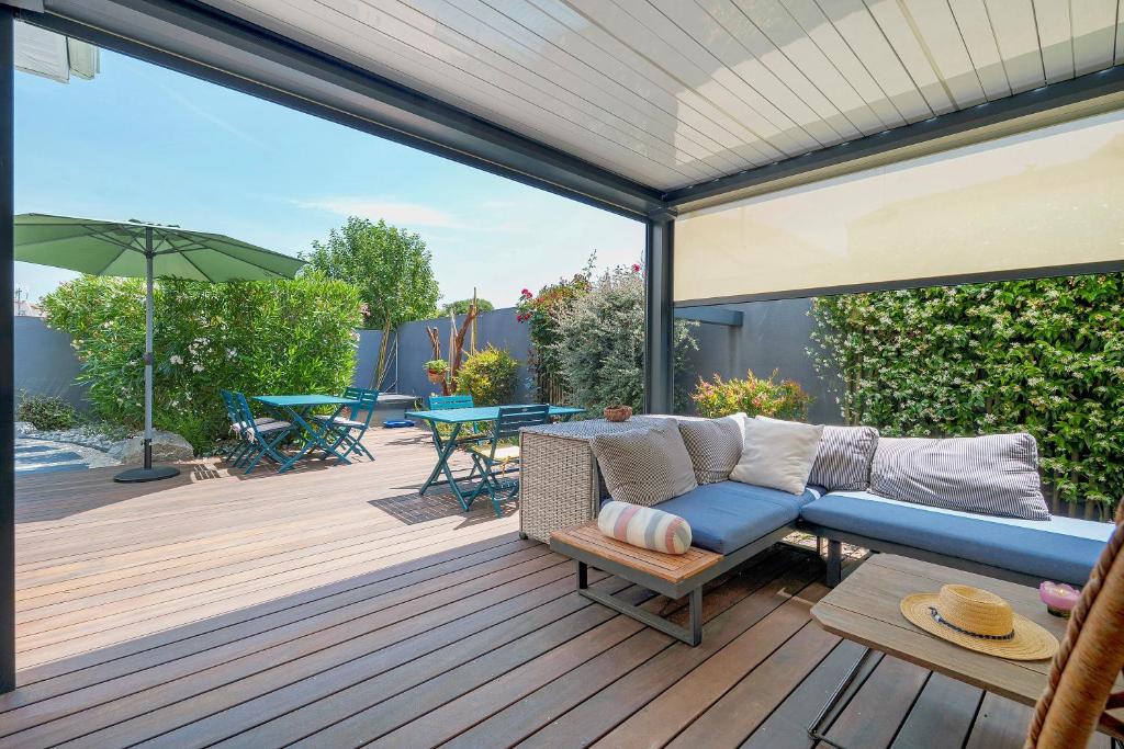 a patio with a blue couch on a wooden deck at Chambres D'hôtes Authentique Pornic in Pornic