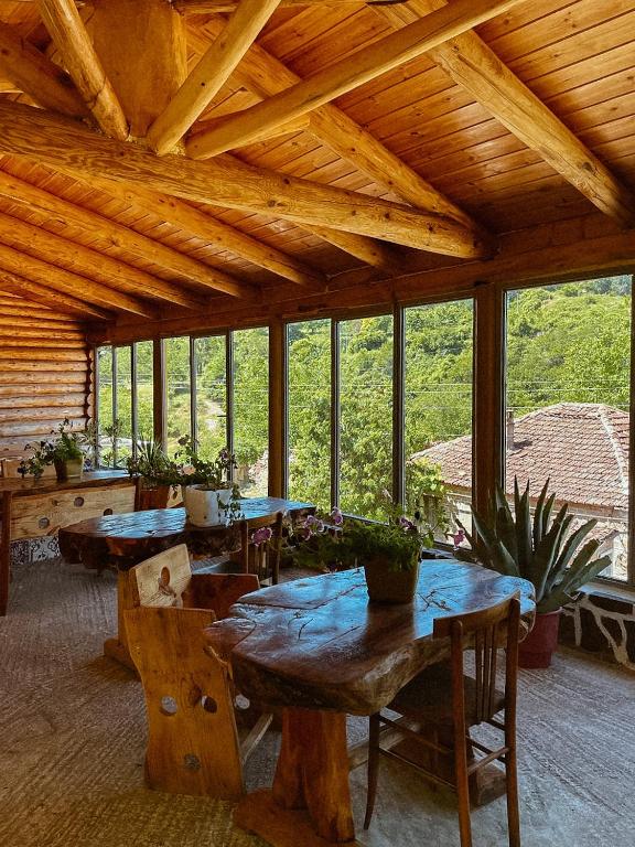 a large room with tables and chairs and windows at VEIS Country House in Kamenicë