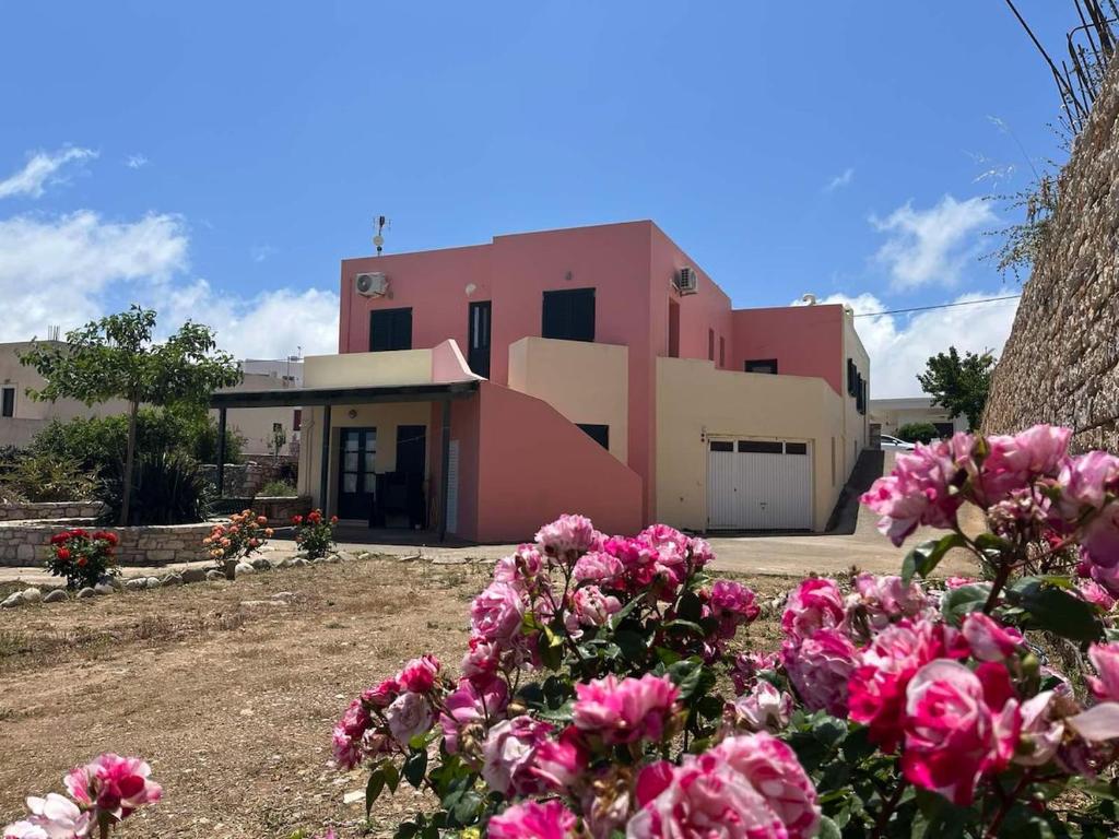 a pink building with flowers in front of it at Choios' House in Kondoliánika