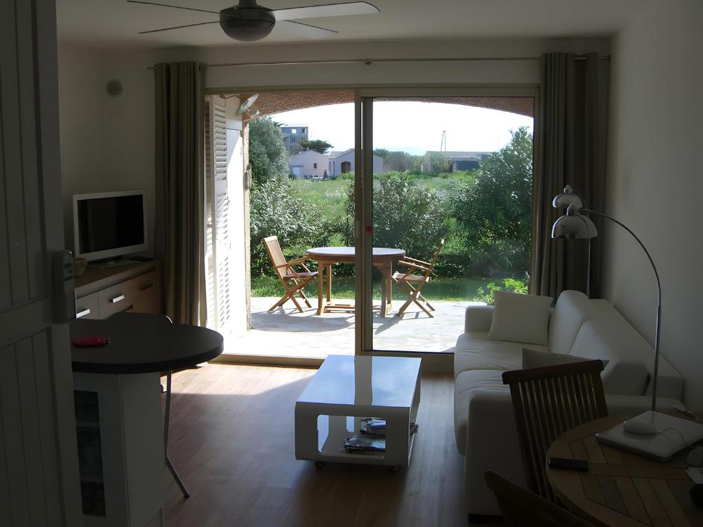 a living room with a couch and a sliding glass door at Appart avec terrasse proche mer in Macinaggio
