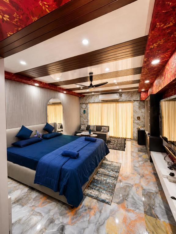 a bedroom with a blue bed and a living room at weston Hotel And Resorts in kolkata