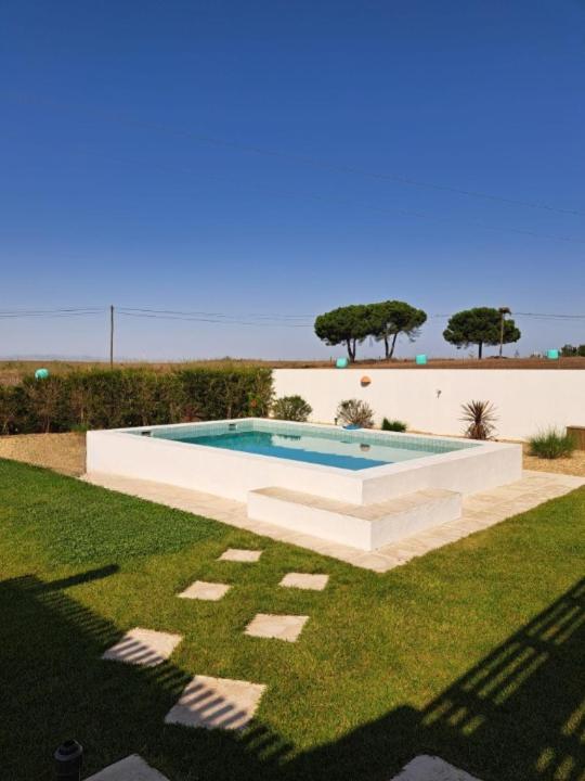 a swimming pool in the middle of a lawn at Casa dos Foros in Odemira