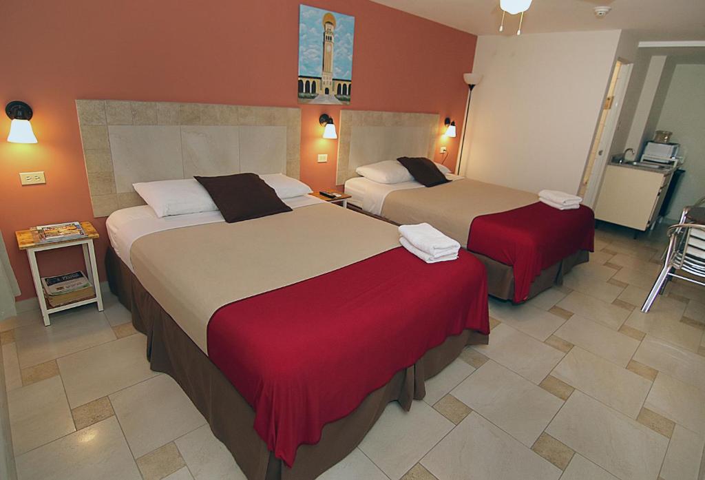 ein Hotelzimmer mit 2 Betten und roten Wänden in der Unterkunft Dreams Hotel Puerto Rico in San Juan