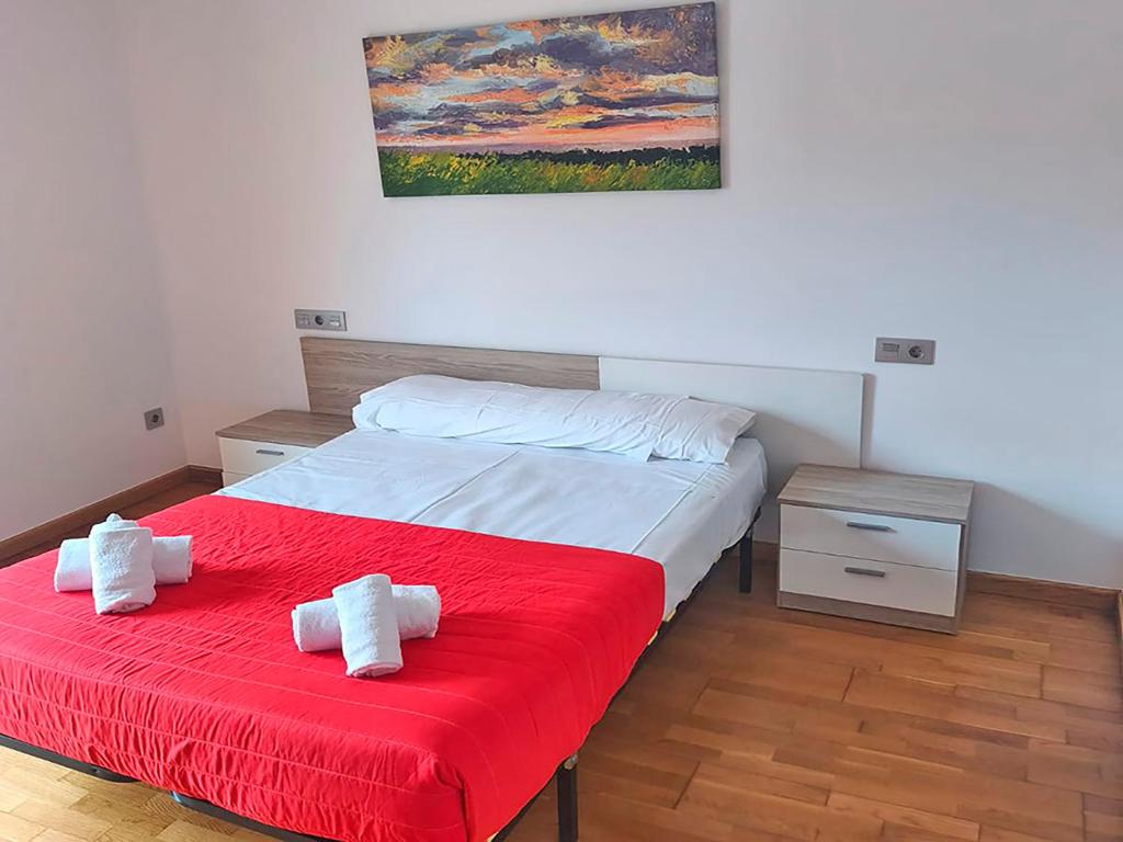 a bedroom with a bed with a red blanket at Apartamentos Illa de Arousa 3000 in Isla de Arosa