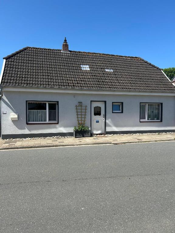 a white house on the side of a street at Kleine Hafenperle in Varel