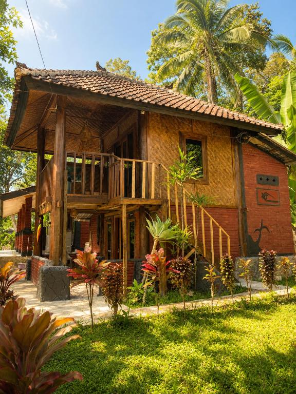 a house with a porch and a balcony at Tetebatu Garden Lombok in Tetebatu