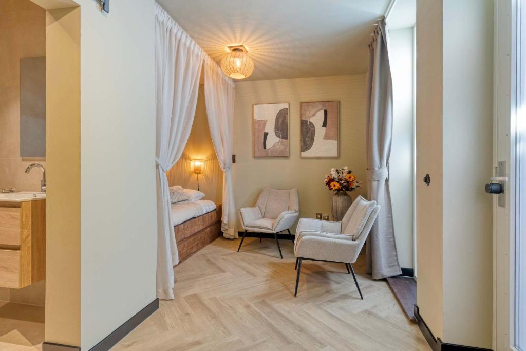 a bedroom with a bed and a chair in a room at Boutique Hotel Alkmaar - City Rooms & Apartments in Alkmaar