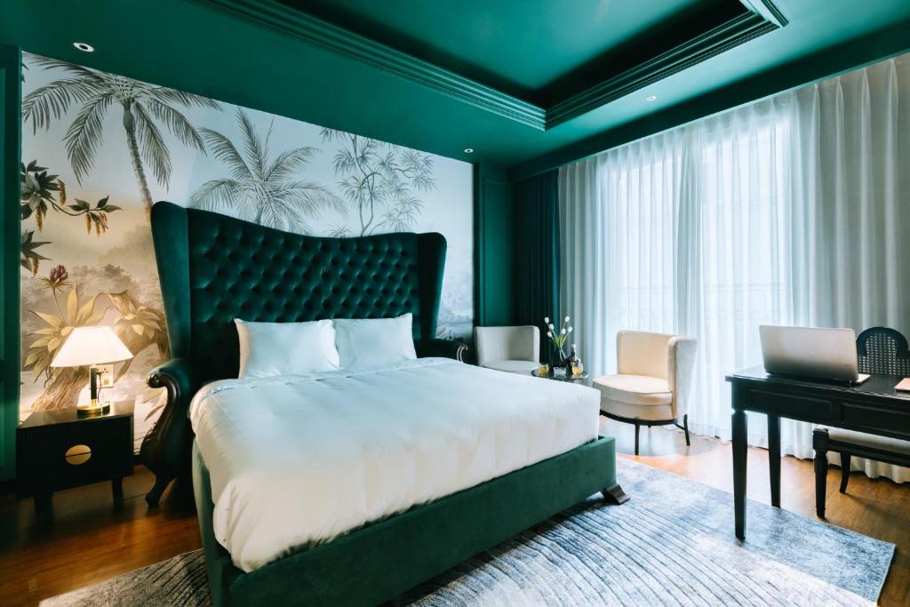 a bedroom with a large bed and a desk at Brilliant Jade Suites in Hanoi