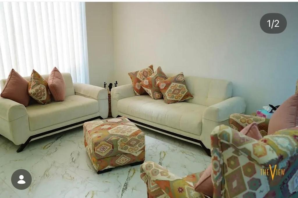 a living room with two couches and a table at THE VIEW chalet in Makhrabā