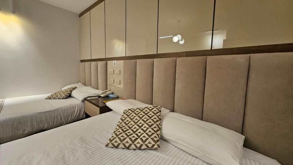 a hotel room with two beds and a cabinet at Aura Garden City Hotel in Cairo
