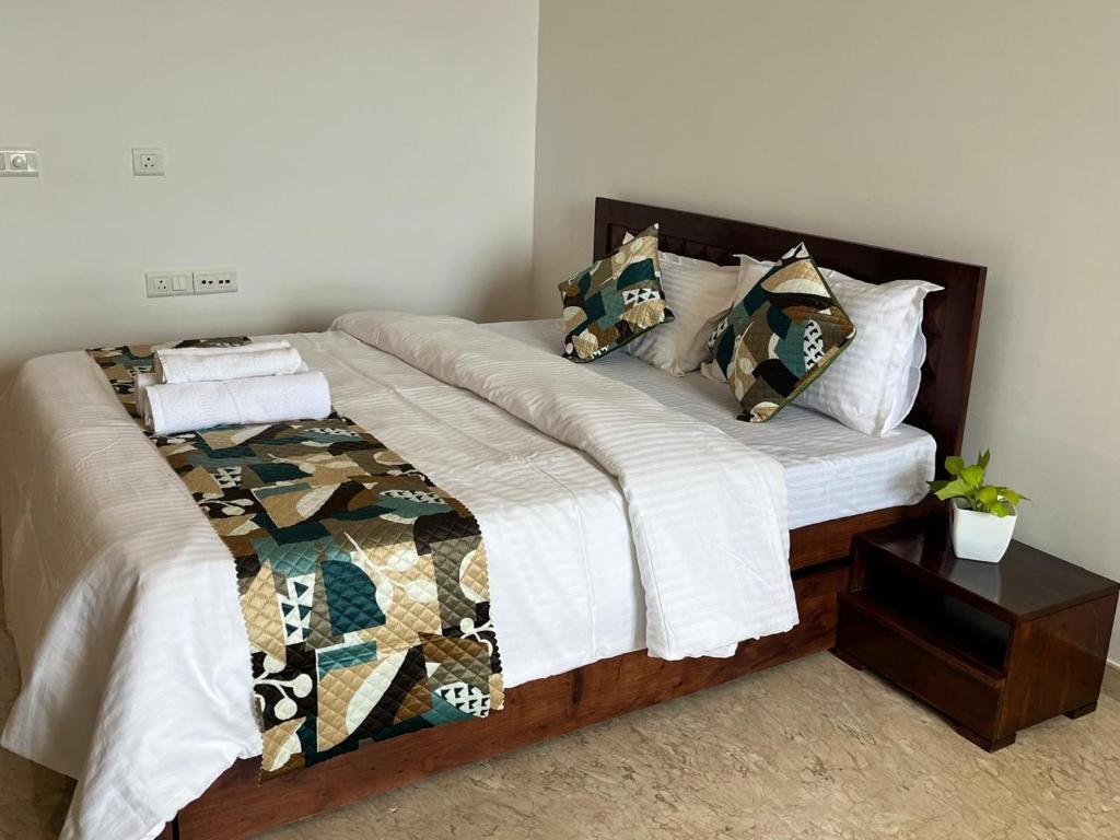 a bed with white sheets and pillows on it at Luna Spaces-Riva Nr KIMS Hospital, Bayer House, TCS thane in Thane