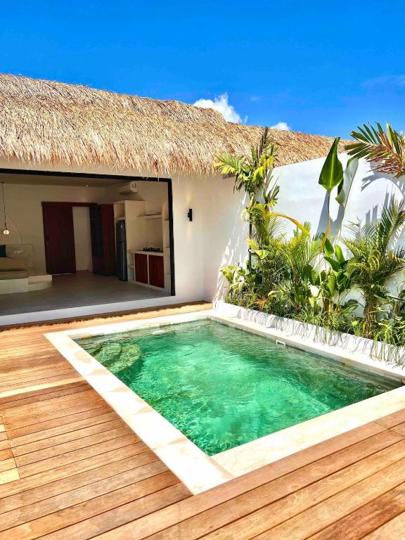 a swimming pool in front of a house at Villa Papì Uluwatu 1 in Bingin Beach