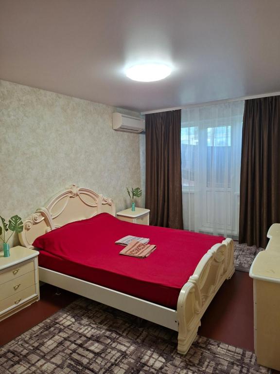 a bedroom with a large bed with a red blanket at Cozy apartment in Kryvyi Rih