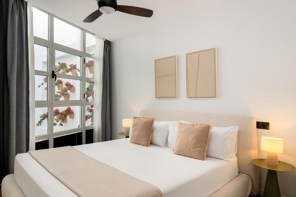 a bedroom with a white bed and a window at MÁ HOMES Postigos in Málaga