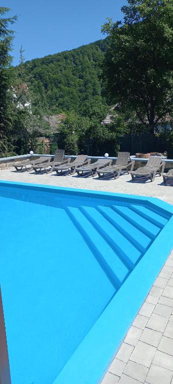 a swimming pool with chairs and a group at Zelena Sadyba Bila Stavka in Yaremche