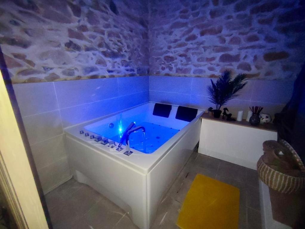 a bath tub with a blue light in a room at Jacuzzi de charme pour 2 in Nîmes