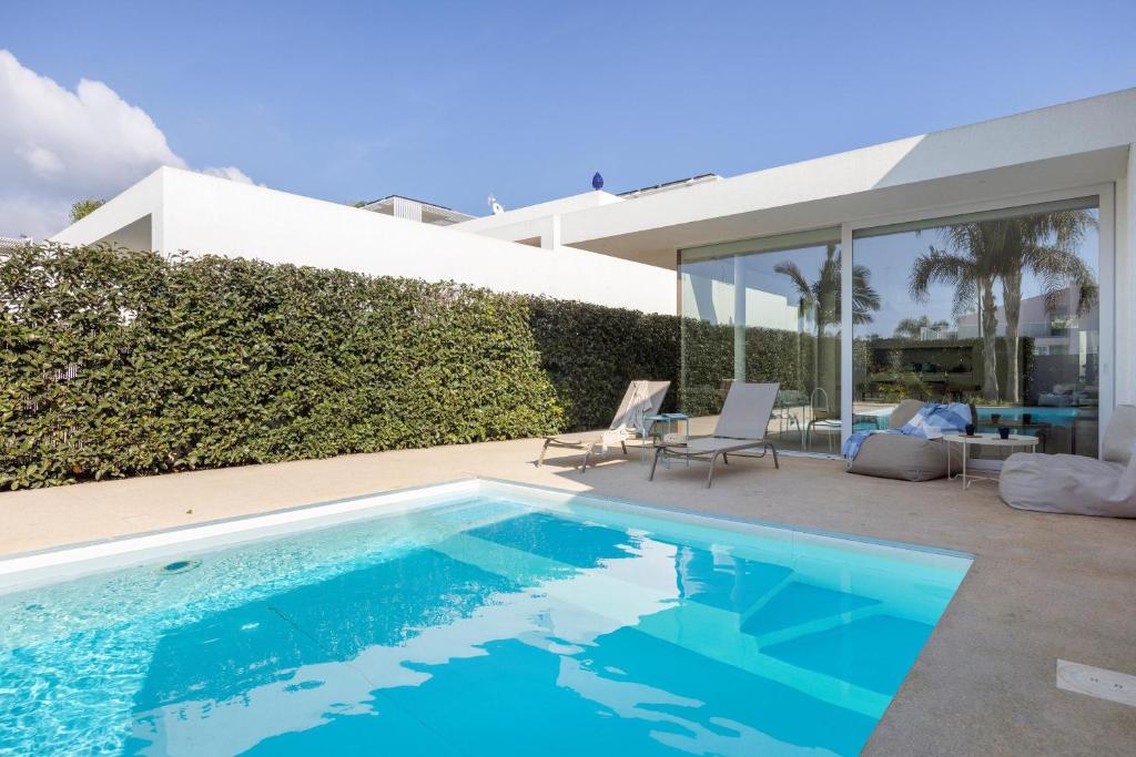 a swimming pool in front of a house at Villa Argentea in Ragusa