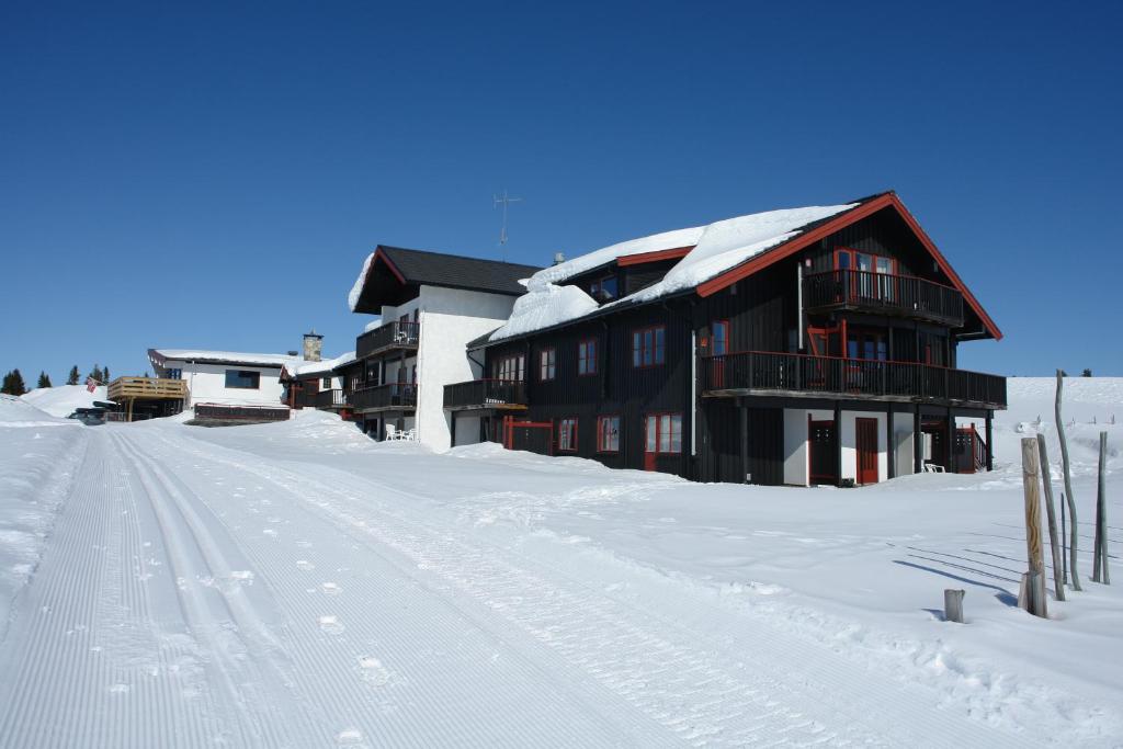 a building in the snow with footprints in the snow at Gålåseter Jotunheimen 5 in Gålå