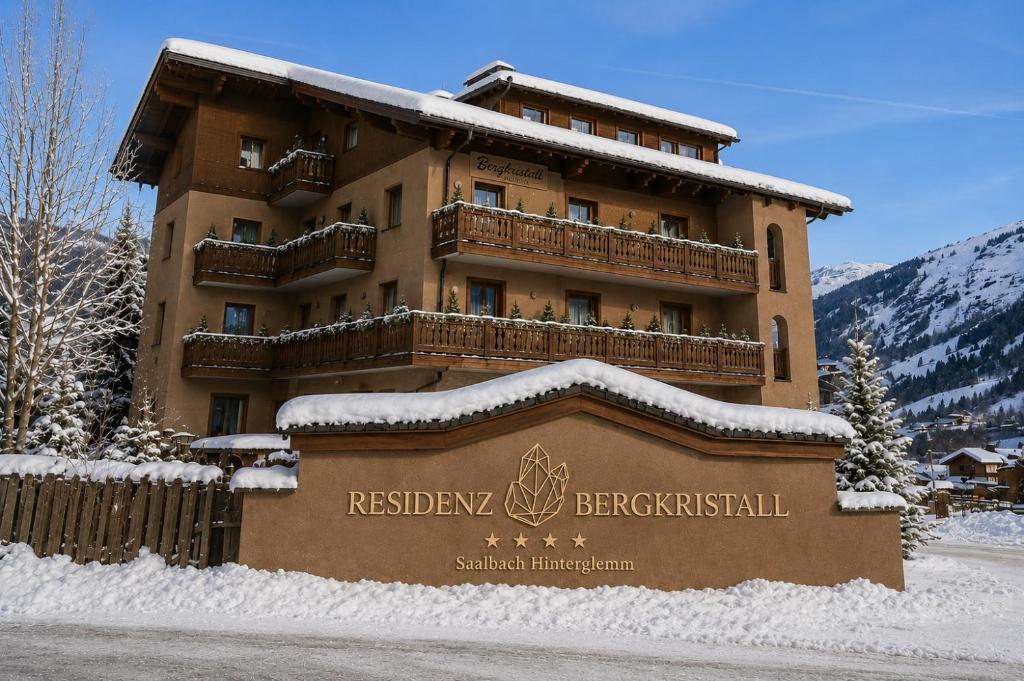 a sign in front of a building in the snow at Residenz Bergkristall in Saalbach-Hinterglemm