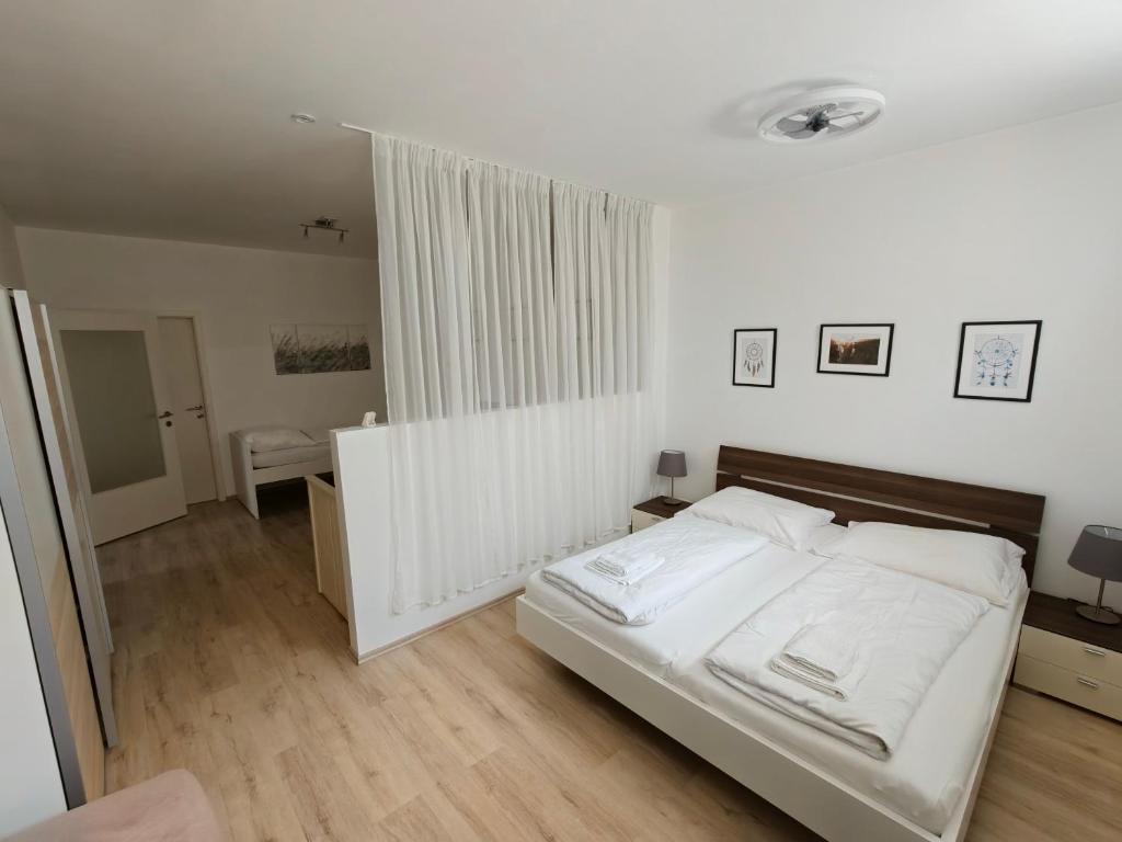 a bedroom with a bed with white sheets at Antonio Appartement in Steinabrückl