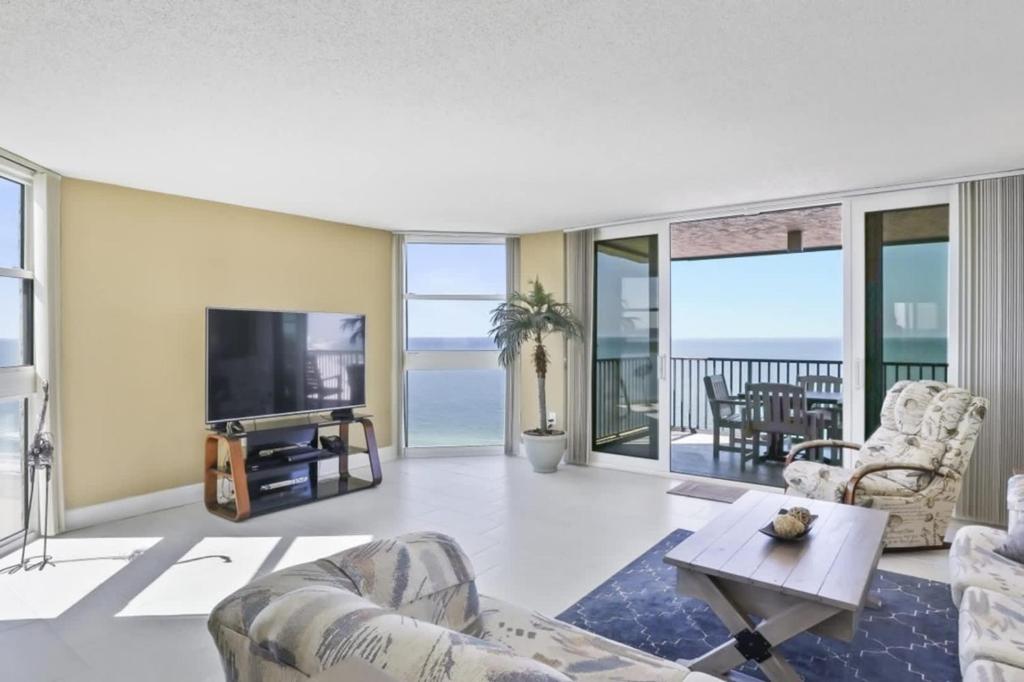 a living room with a view of the ocean at Two Bedroom Corner Condo with Panoramic Gulf Views in Clearwater Beach