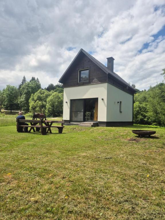 a house with a picnic table in a field at Domek Ranczo Podkówka "przed" Bieszczady in Lipa