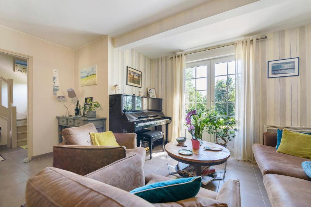 a living room with a couch and a piano at Le Lys De Mer - Chambre in Dragey