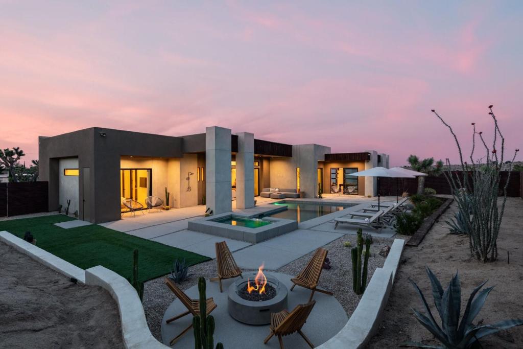 a home with a fire pit in the yard at Windsong Modern compound w pool spa in Yucca Valley