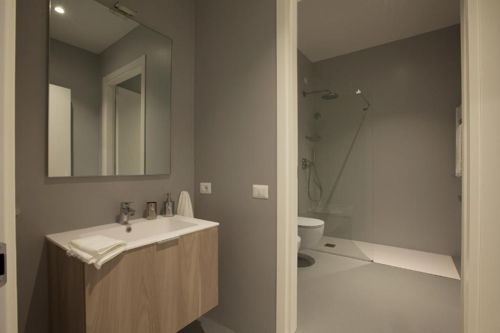 uma casa de banho com um lavatório, um WC e um espelho. em Residenza Dante em Nuoro