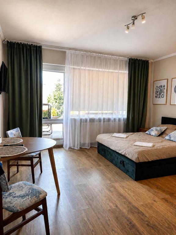 a bedroom with a bed and a table and a window at Belona in Stegna