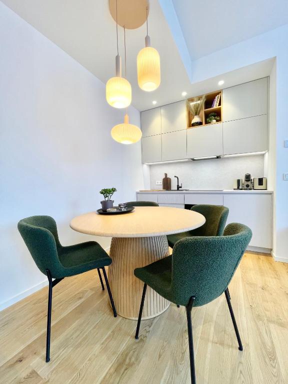 a kitchen with a table and four green chairs at Luxorious Japandi design apartment in Otepää
