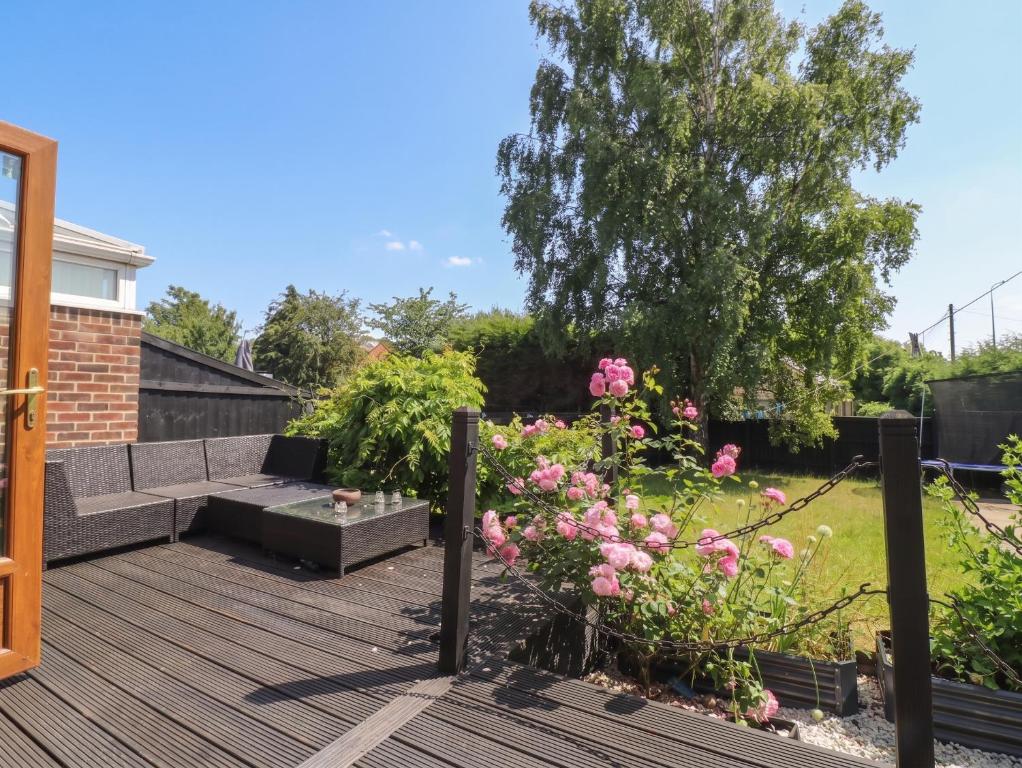 a garden with a wooden deck and pink flowers at 57 Howden Avenue in Doncaster