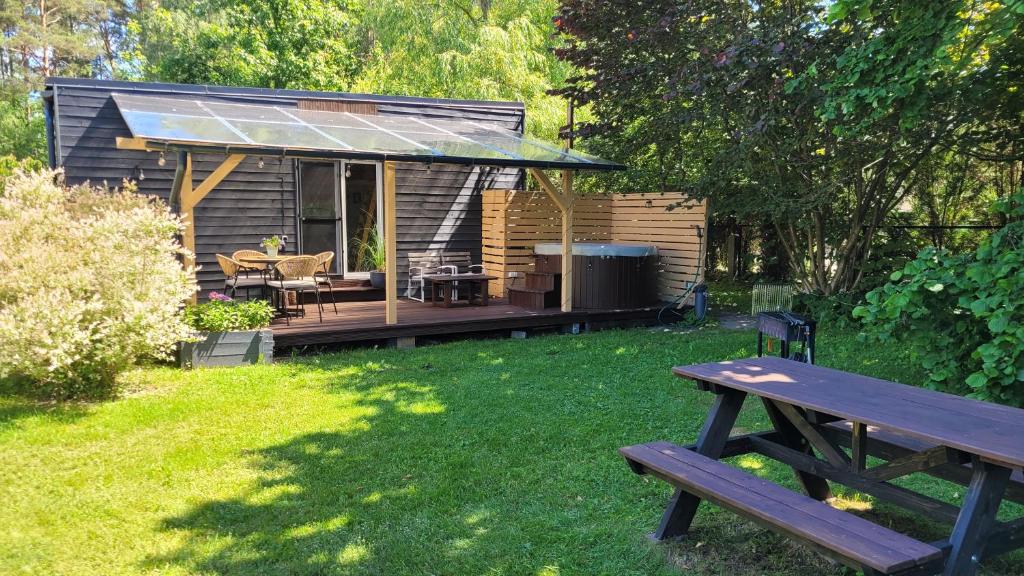 a picnic table in front of a tiny house at Tiny Village Latvia in Bērzciems