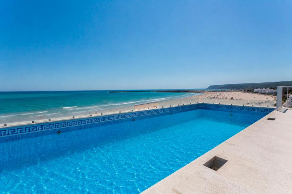 a swimming pool with the beach in the background at Apartamentos Playa Barbate in Barbate