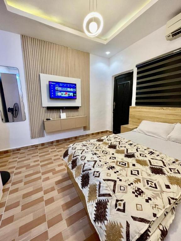 a bedroom with a bed and a flat screen tv at The Hideout in Lagos