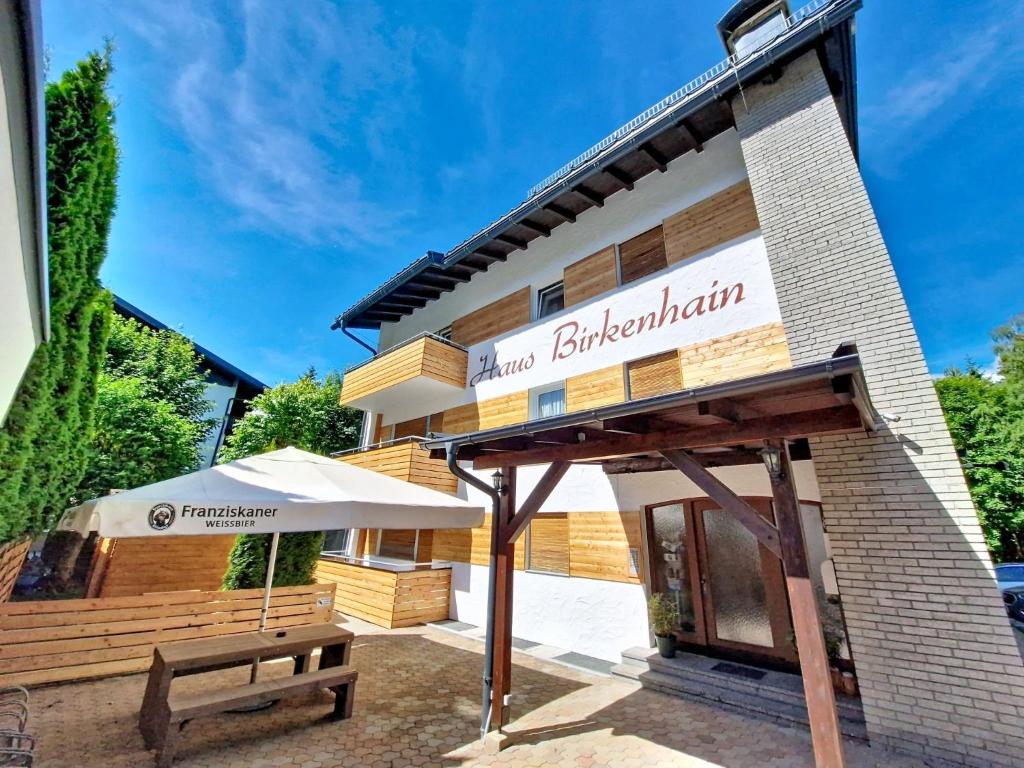 a building with an umbrella and a bench at Apartment Am Birkenhain-28 by Interhome in Seefeld in Tirol