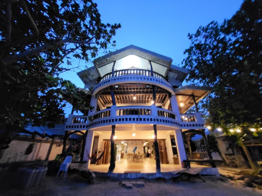 a large blue building with a balcony at night at Feelgood dive resort in Basbas
