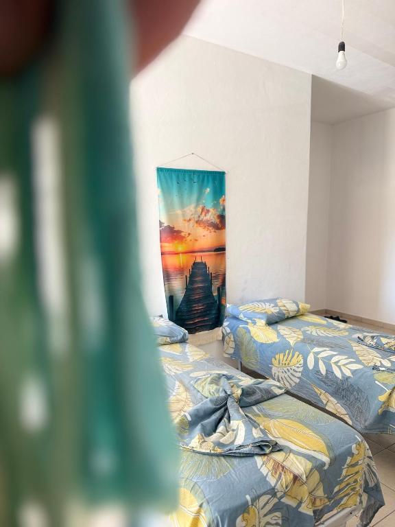 two beds in a room with a painting on the wall at AS Orikum 2 in Orikum