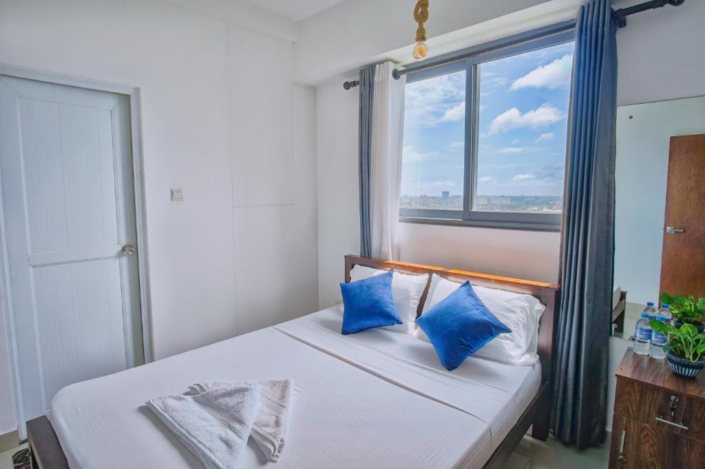 a bedroom with a bed with blue pillows and a window at Skyline Views Pool access Central Location in Yakbedda