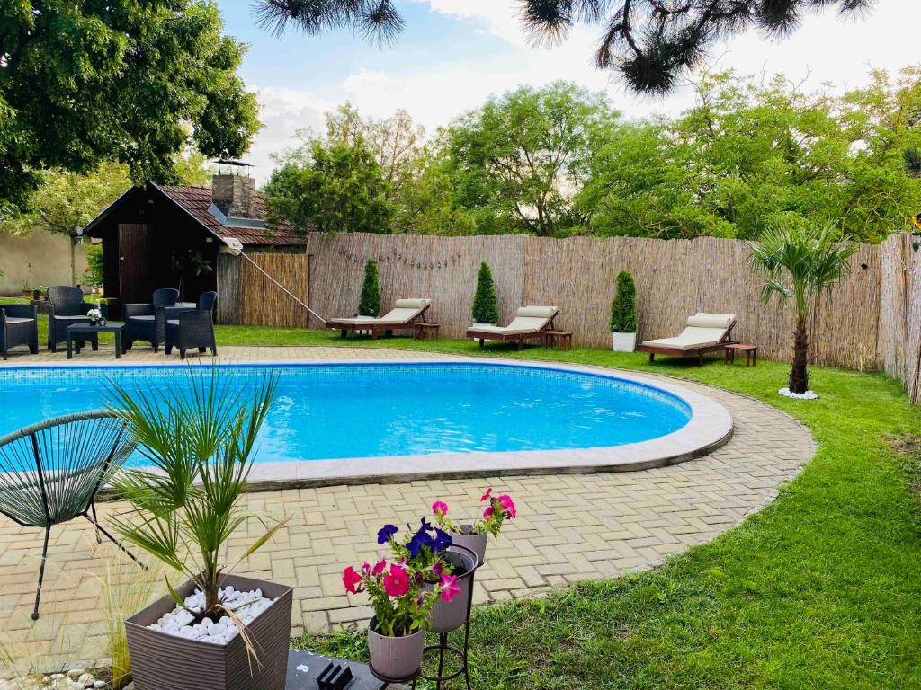 a swimming pool in a yard with furniture and flowers at Pool House in Subotica