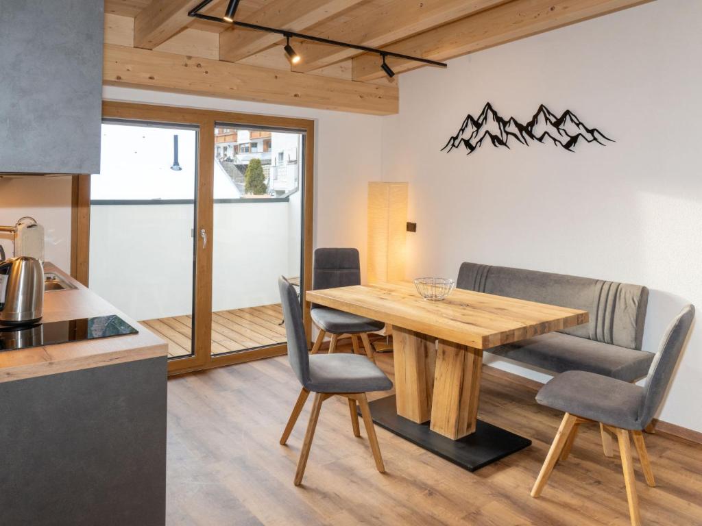 a kitchen and dining room with a wooden table and chairs at Apartment Miramonte-6 by Interhome in Kappl