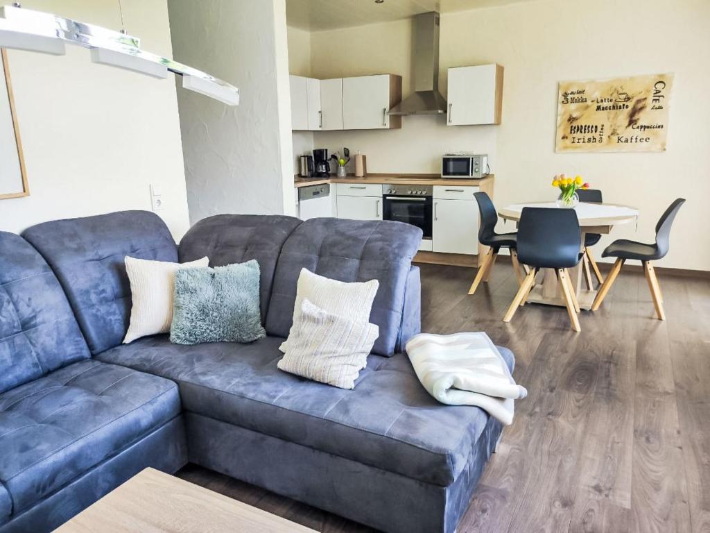 a living room with a blue couch and a kitchen at Apartment Ober Langengarten by Interhome in Pittenbach