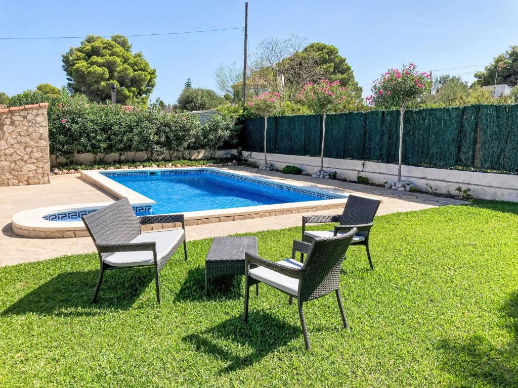 a yard with three chairs and a swimming pool at Holiday Home Casa Blumer by Interhome in Les tres Cales