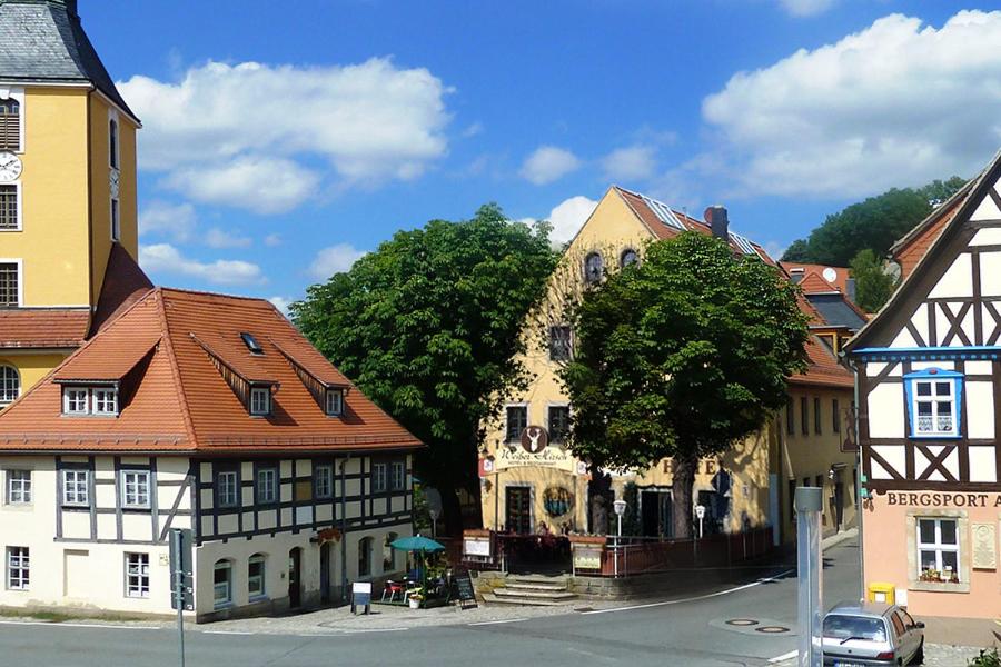 a group of buildings in a town with a street at Burgblick Hohnstein - Pension in Hohnstein