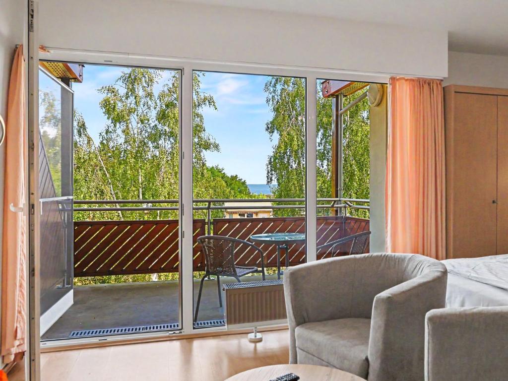 a bedroom with a view of a balcony at Apartment Düneneck App-17 by Interhome in Zempin