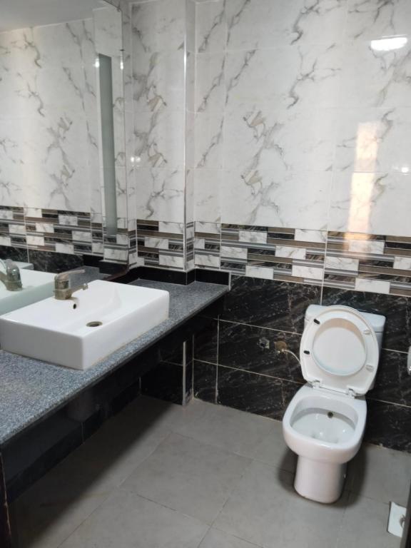 a bathroom with a white toilet and a sink at Playa Hotel in Dahab