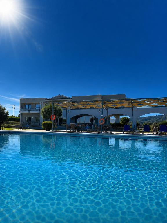 a large pool of blue water in front of a building at Vians Olympia Resort in Olympia