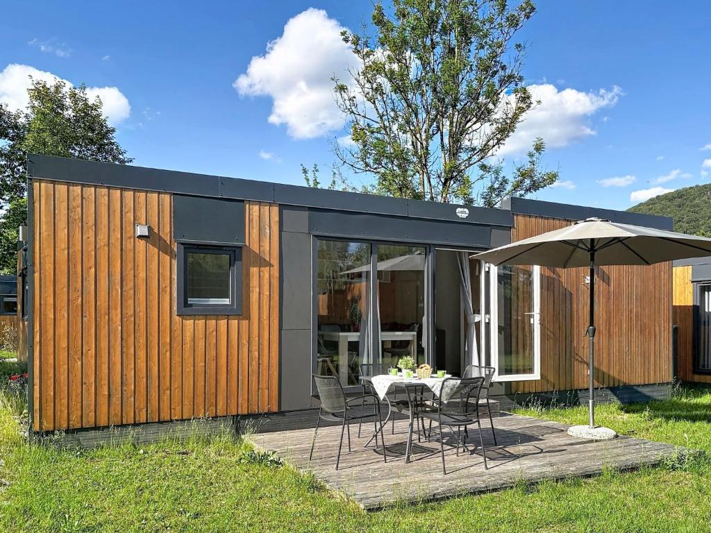 a small house with a table and an umbrella at Holiday Home Tiny Haus Libelle by Interhome in Riedenburg