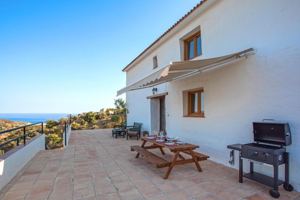 a patio with a table and a grill on a building at Campo and relax Málaga country house in Málaga